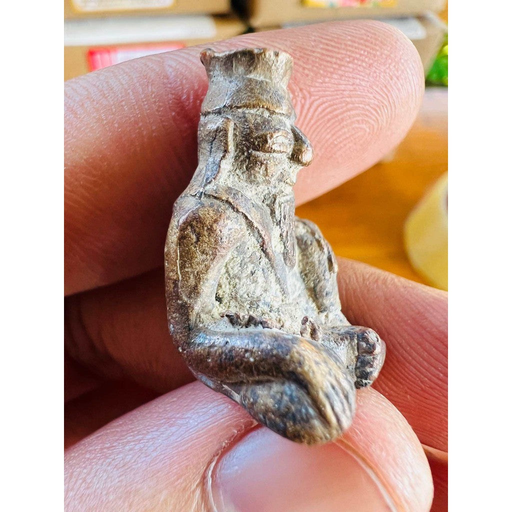 Close-up of ancient protection amulet limited edition held between fingers by Thai Blessing Co