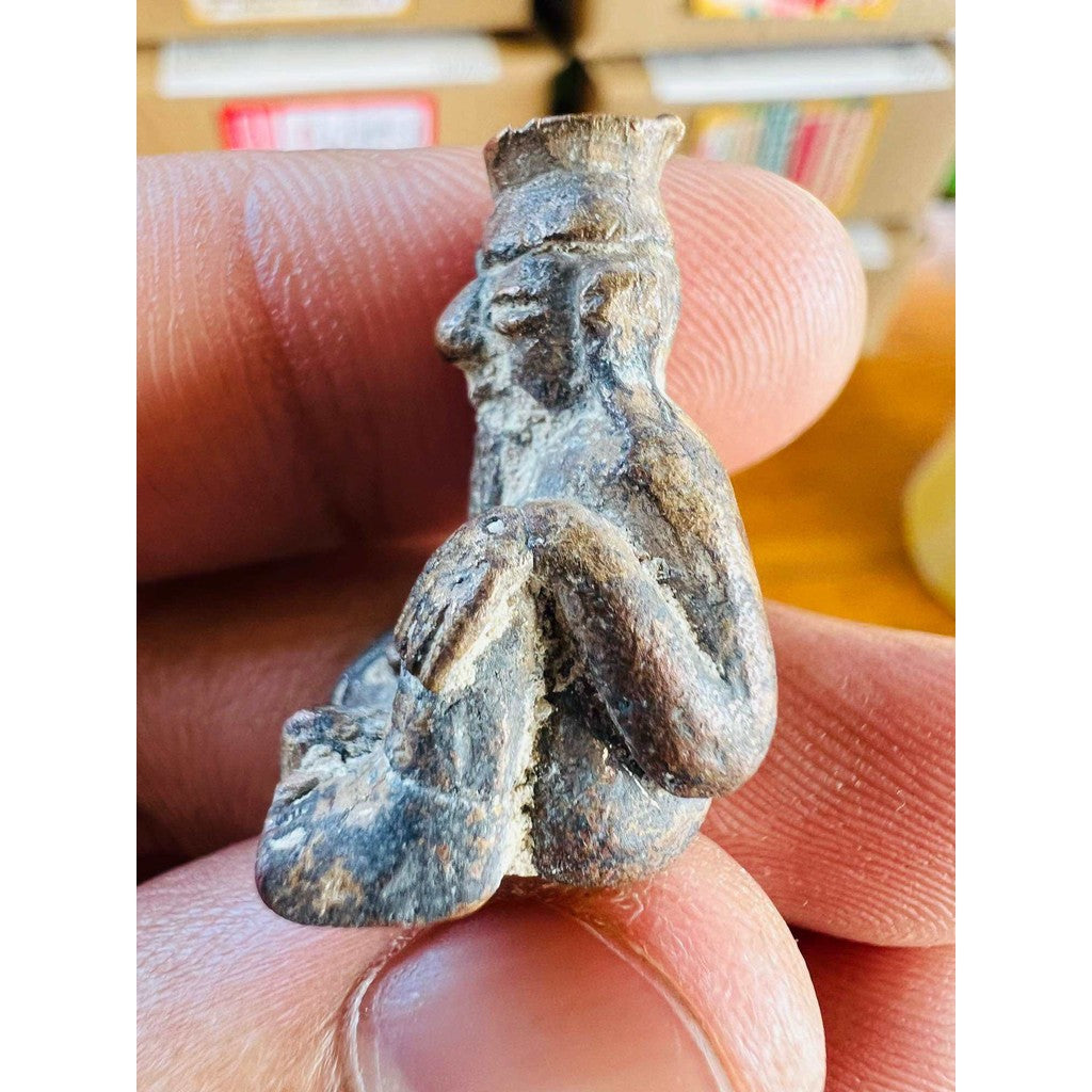 Ancient protection amulet limited edition held between fingers showing detailed weathered carving