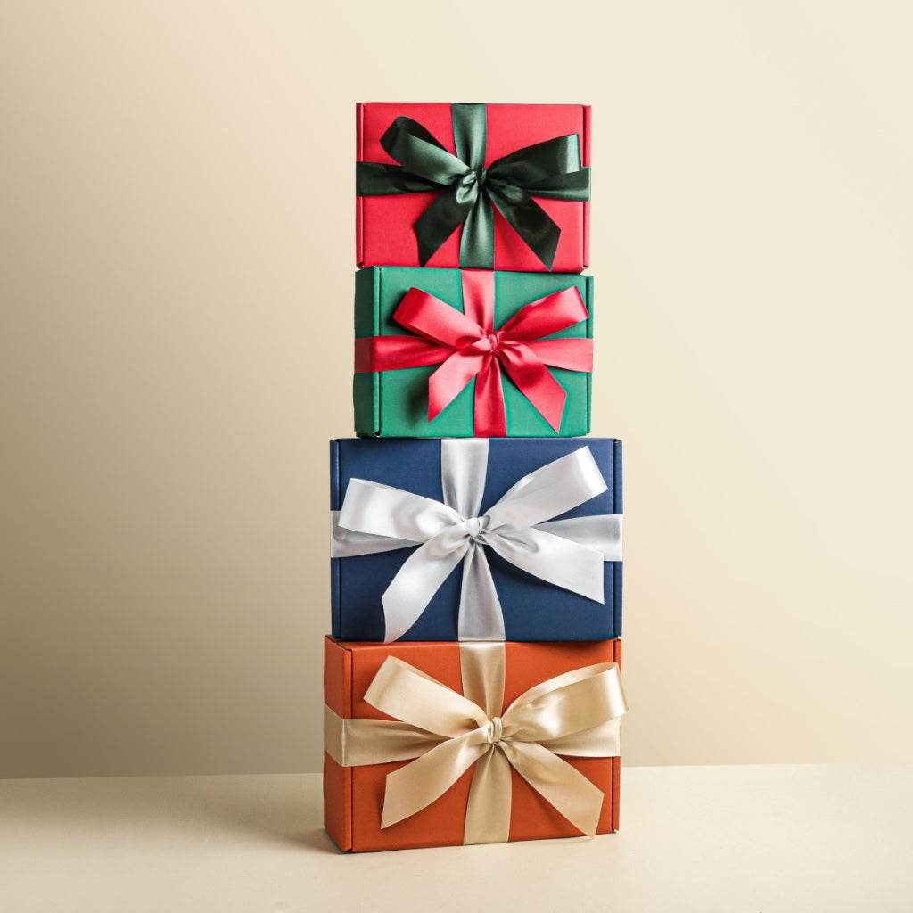 Stack of four colorful gift boxes with ribbons for aromatherapy gift box for women and men