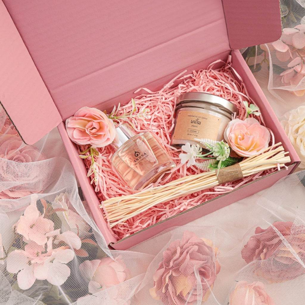 Christmas aromatherapy gift set by One-Sake.com with scented candle, diffuser sticks, and decorative flowers in pink box