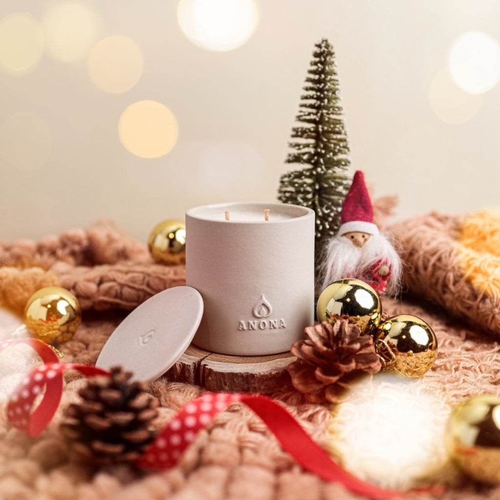 Handmade ceramic aromatherapy candle in white container with holiday decor on knitted surface