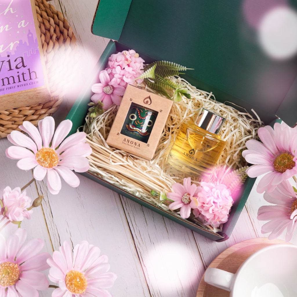 Herbal aroma gift set with essential oil and diffuser in green box surrounded by pink flowers