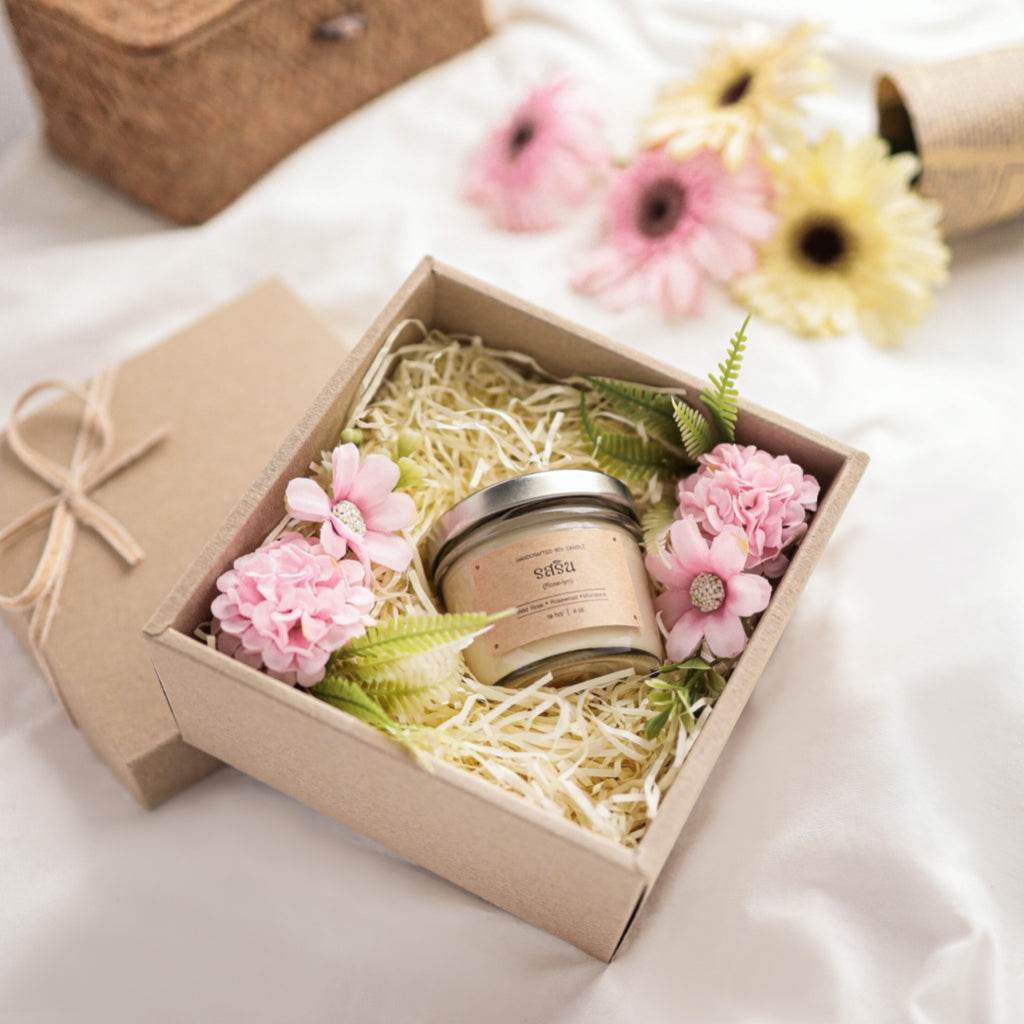 Natural aromatherapy candles in a gift box with pink flowers and green leaves for home decor