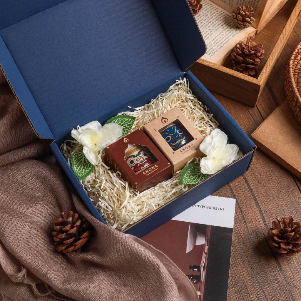 Natural essential oil diffuser set in gift box with decorative flowers and pinecones on wooden table