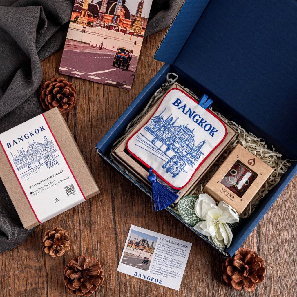 Thai aroma gift set with Bangkok-themed pouch, essential oil, and decorative flowers in a blue box