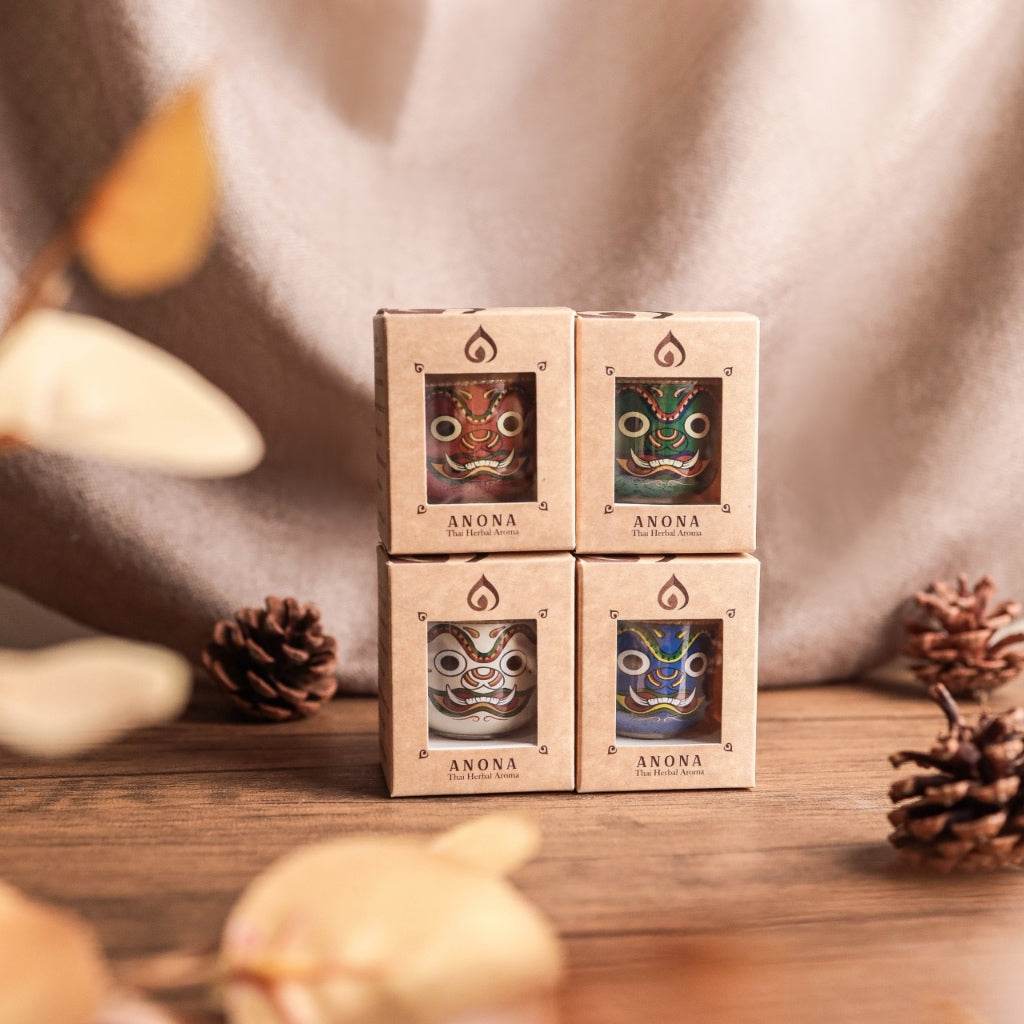 Set of four boxed Thai herbal aroma sachet with traditional designs displayed on wooden surface