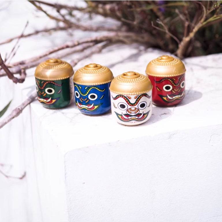 Colorful Thai herbal aroma sachet containers with traditional mask designs and gold lids