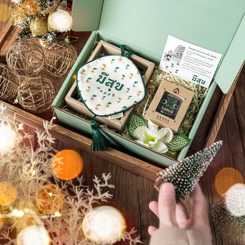 One-Sake.com unique Thai gift box with scented candle, essential oils, and decorative flower inside a green open box