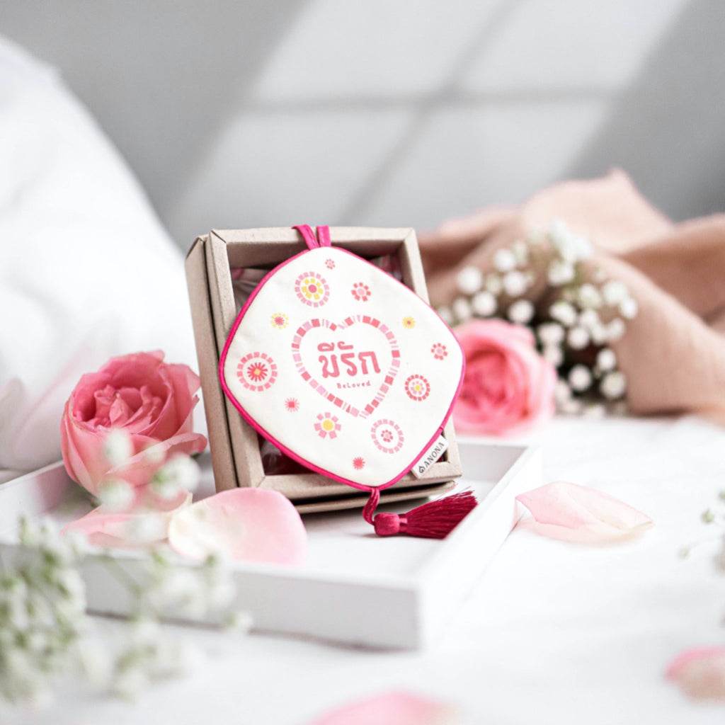 Valentine's day gift box for her with decorative heart-themed item and pink roses on white tray