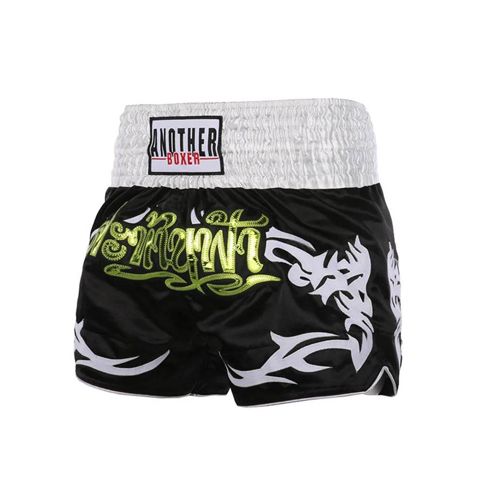 Black Muay Thai boxing shorts with white smocked waistband green Thai script and white tribal patterns