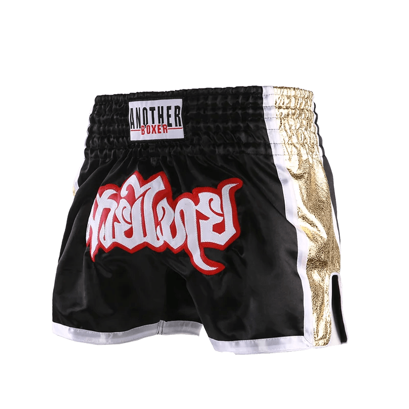 Muay Thai boxing shorts unisex black with gold side panels white trim elastic waistband and red Thai script