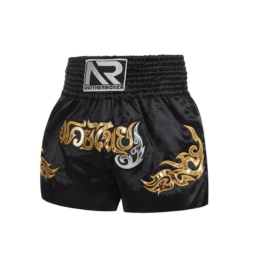 Black satin Muay Thai boxing shorts unisex with gold Thai script and flame embroidery and wide elastic waistband for training