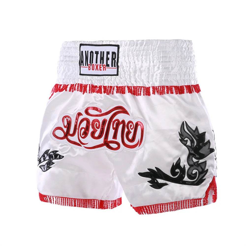 White satin Muay Thai boxing shorts with red trim Thai script and black tribal motifs by Thai Blessing Co