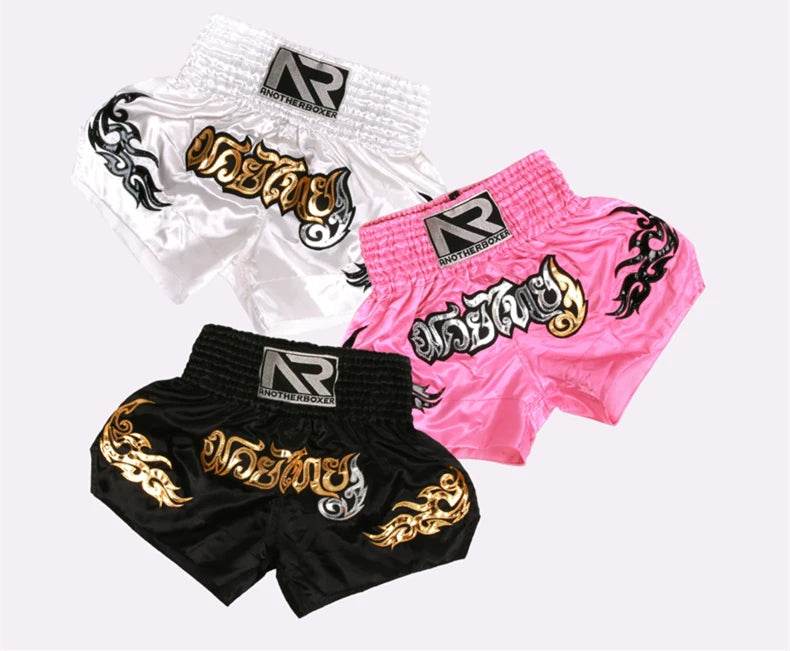 Muay Thai shorts unisex three pairs in white pink and black with gold Thai script and tribal designs by Thai Blessing Co