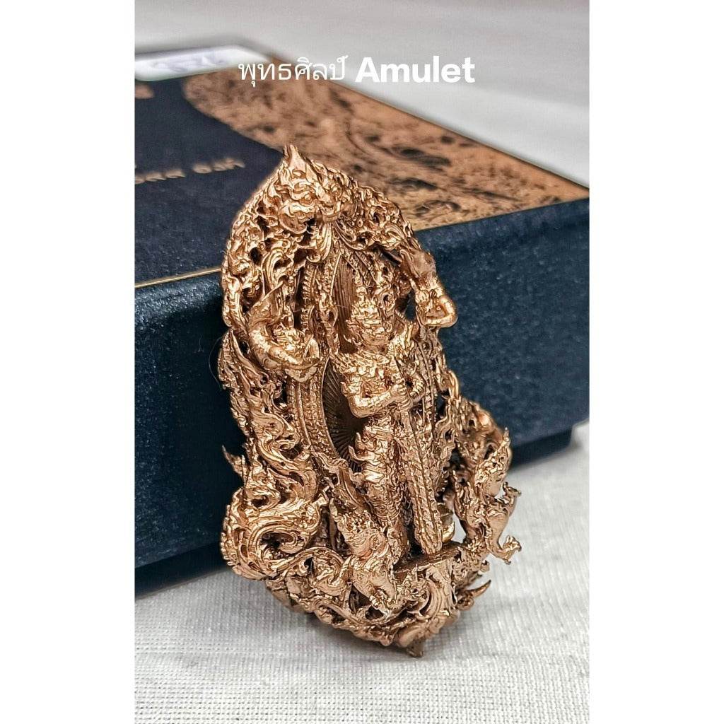 Intricately detailed authentic Thai blessed amulet in gold with traditional design standing against a dark box