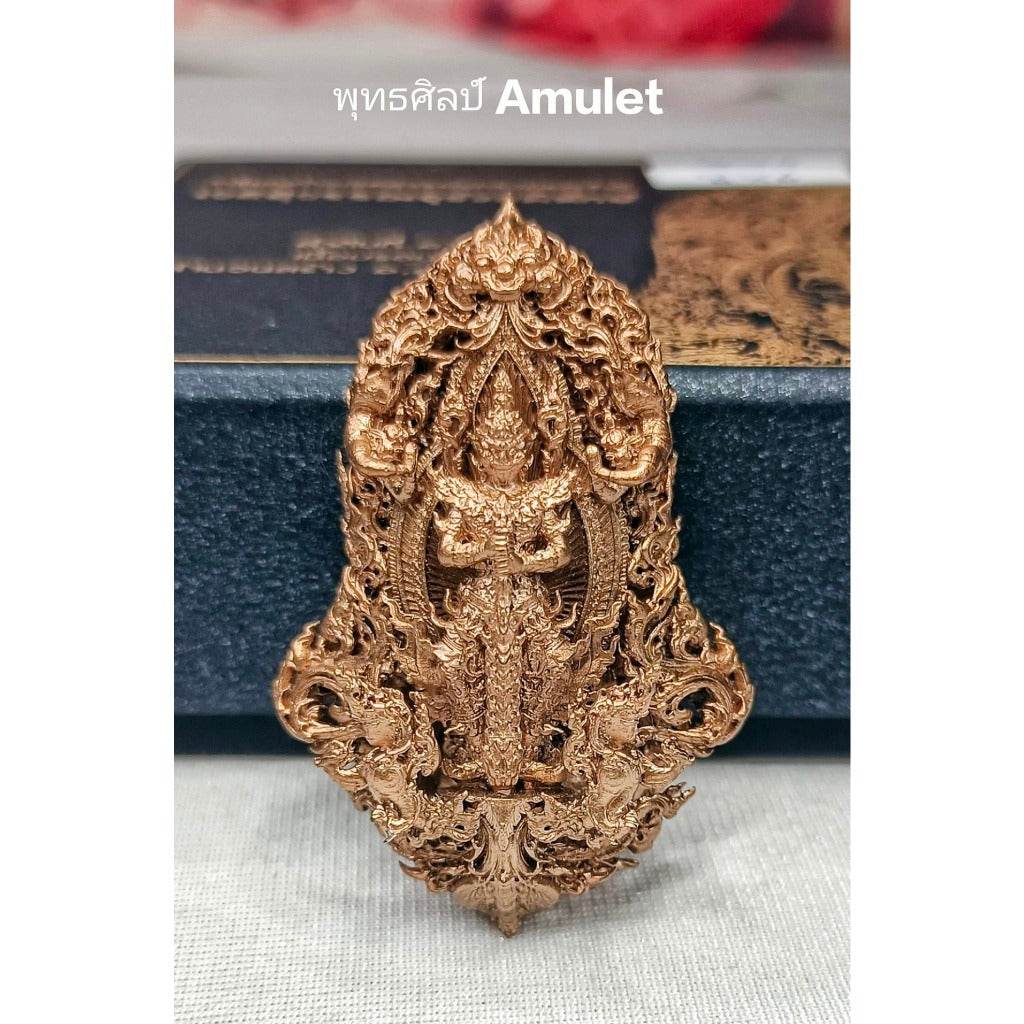 Intricate gold authentic Thai blessed amulet with detailed traditional design in front of a black box