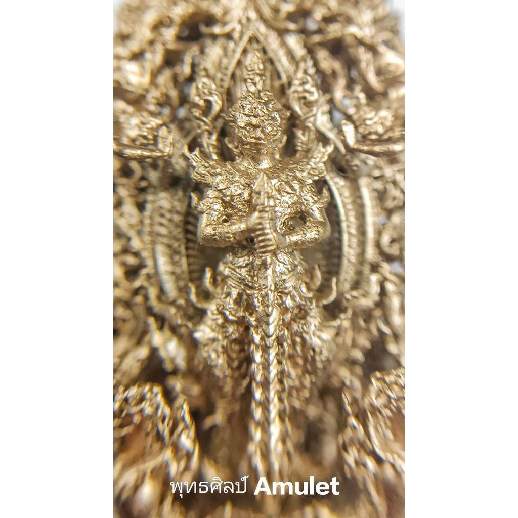 Close-up of an authentic Thai blessed amulet featuring intricate gold detailing and a guardian figure
