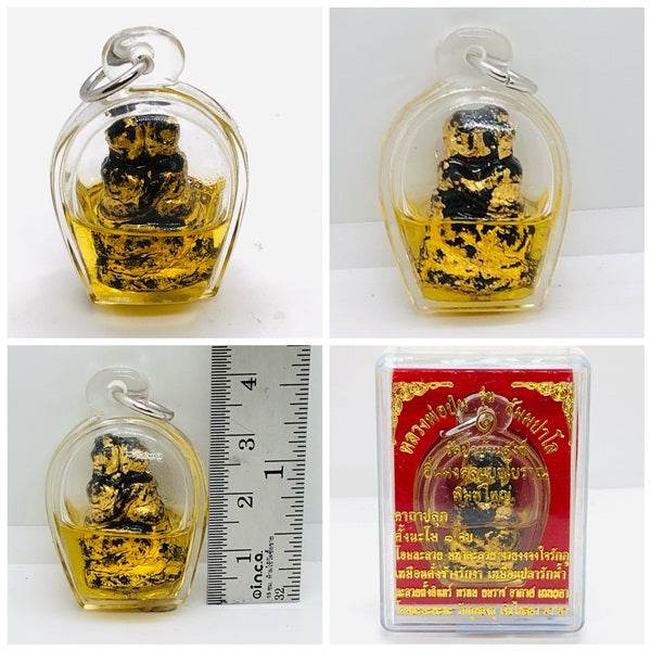 Authentic Thai blessing amulet in clear case with gold and black statue for spiritual protection