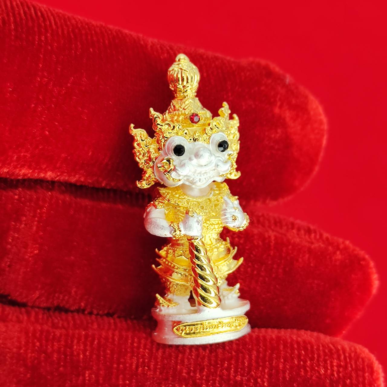 Gold and white authentic Thai protective amulet depicting a mythical creature with intricate details