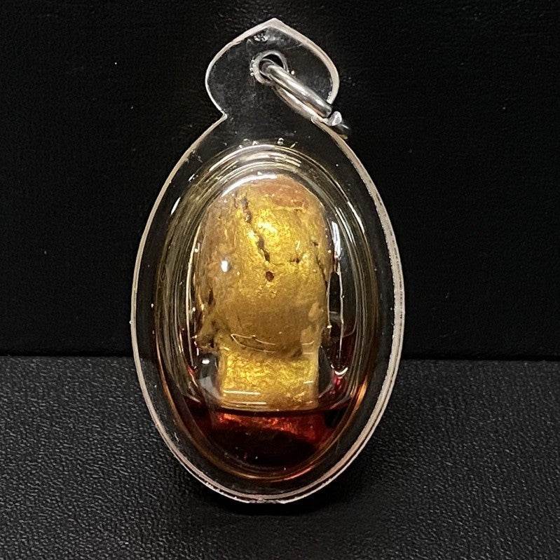 Authentic Thai spirit amulet encased in a clear pendant for protection and good fortune
