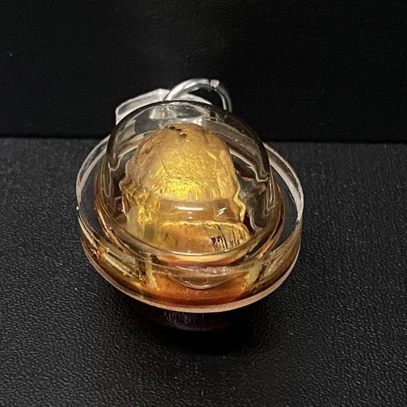 Authentic Thai spirit amulet encased in clear resin showing intricate details and vibrant colors