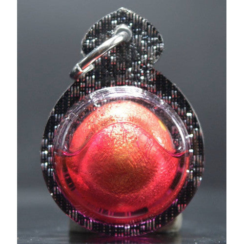 Authentic Thai spiritual charm ball in red and gold encased in black protective holder