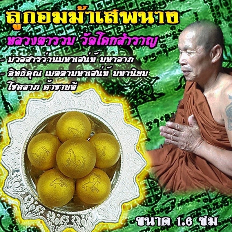 Authentic Thai spiritual charm ball set with golden spheres displayed on a silver ornate plate with a monk praying nearby