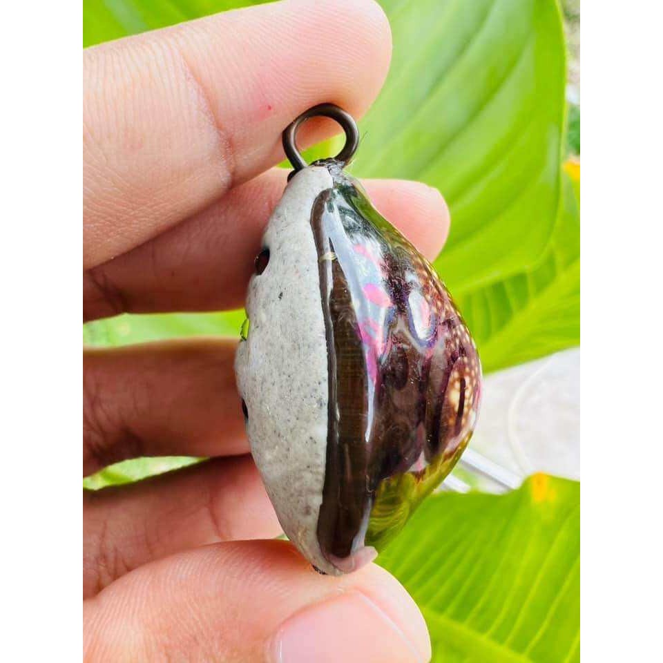 Hand holding Bai Kae Supreme Protection amulet with natural stone and metal loop pendant