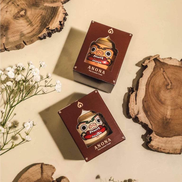 Bangkok herbal gift set with ANONA scented candles in decorative packaging placed on wooden slices