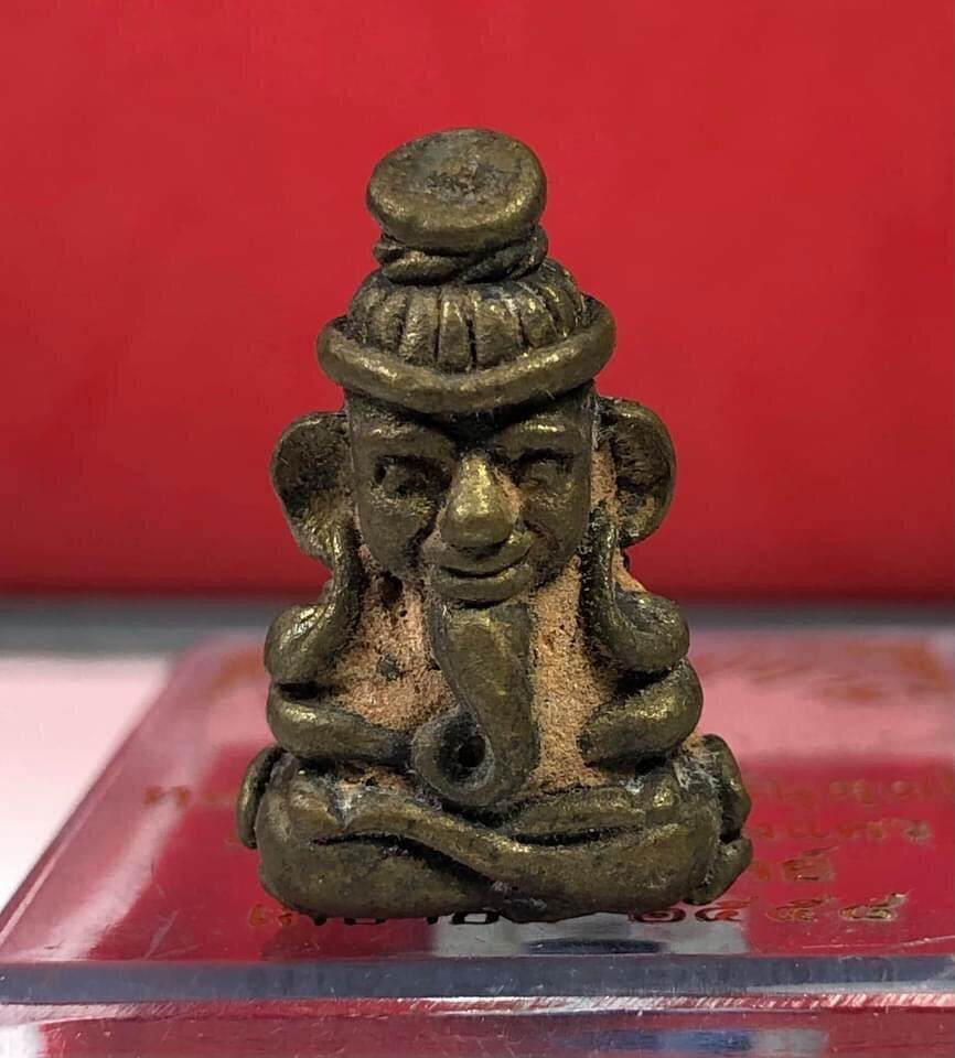 Borom Kru Phu Phu Ruesi Amulet Wealth Calling Edition small aged bronze meditating hermit figurine on red background