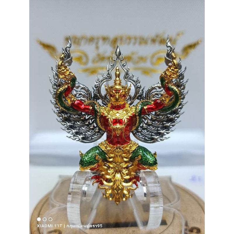 Blessed Thai talisman for wealth featuring a detailed red green and gold deity figure with intricate wings