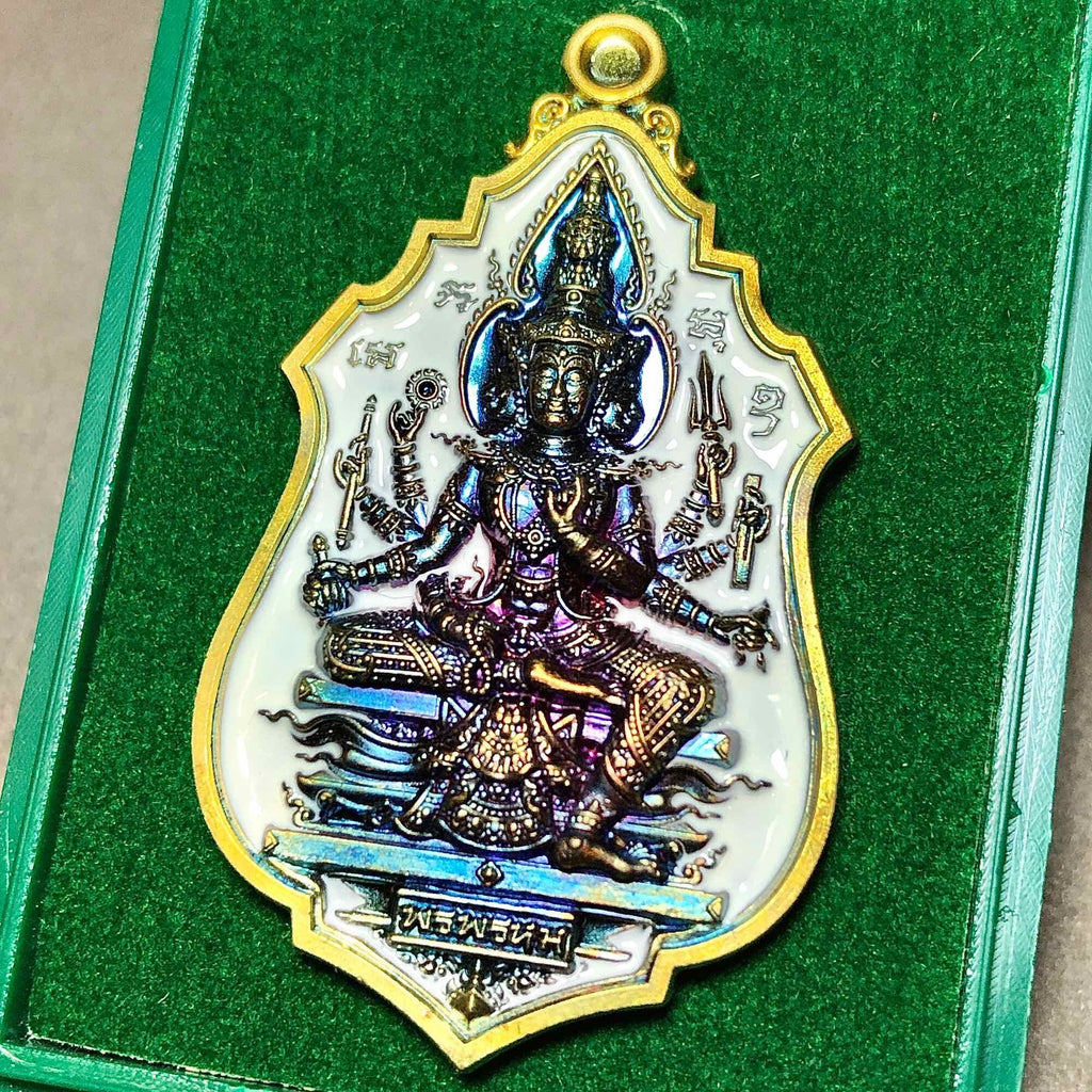 Brahma blessing amulet Thailand featuring an intricate design and vibrant colors in a protective casing