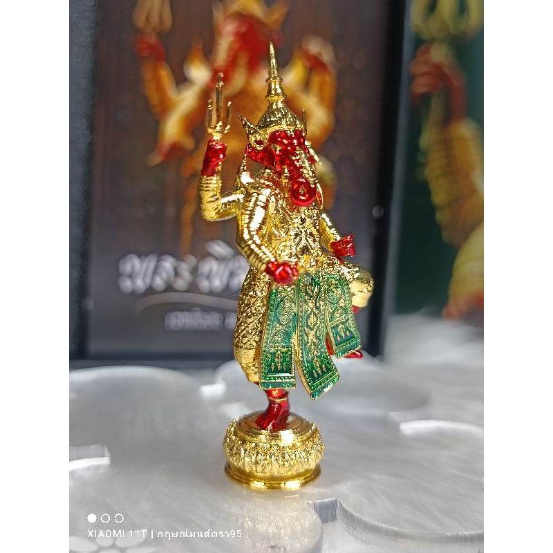 Bronze Ganesha statue blessed in temples with intricate gold and red detailing and green cloth