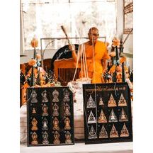Buddhist protection amulet Thailand displayed with a monk in an orange robe during a spiritual ceremony