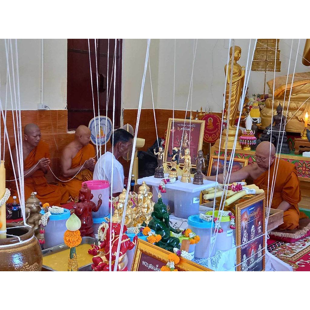 Ganesha on lotus base for wealth statue among Buddhist monks performing a traditional blessing ritual