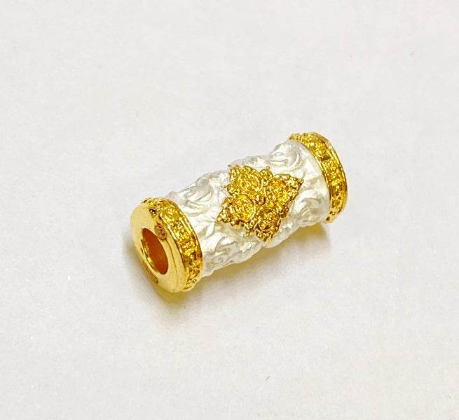 Charm and attraction Thai talisman bead with intricate golden detailing on a white background