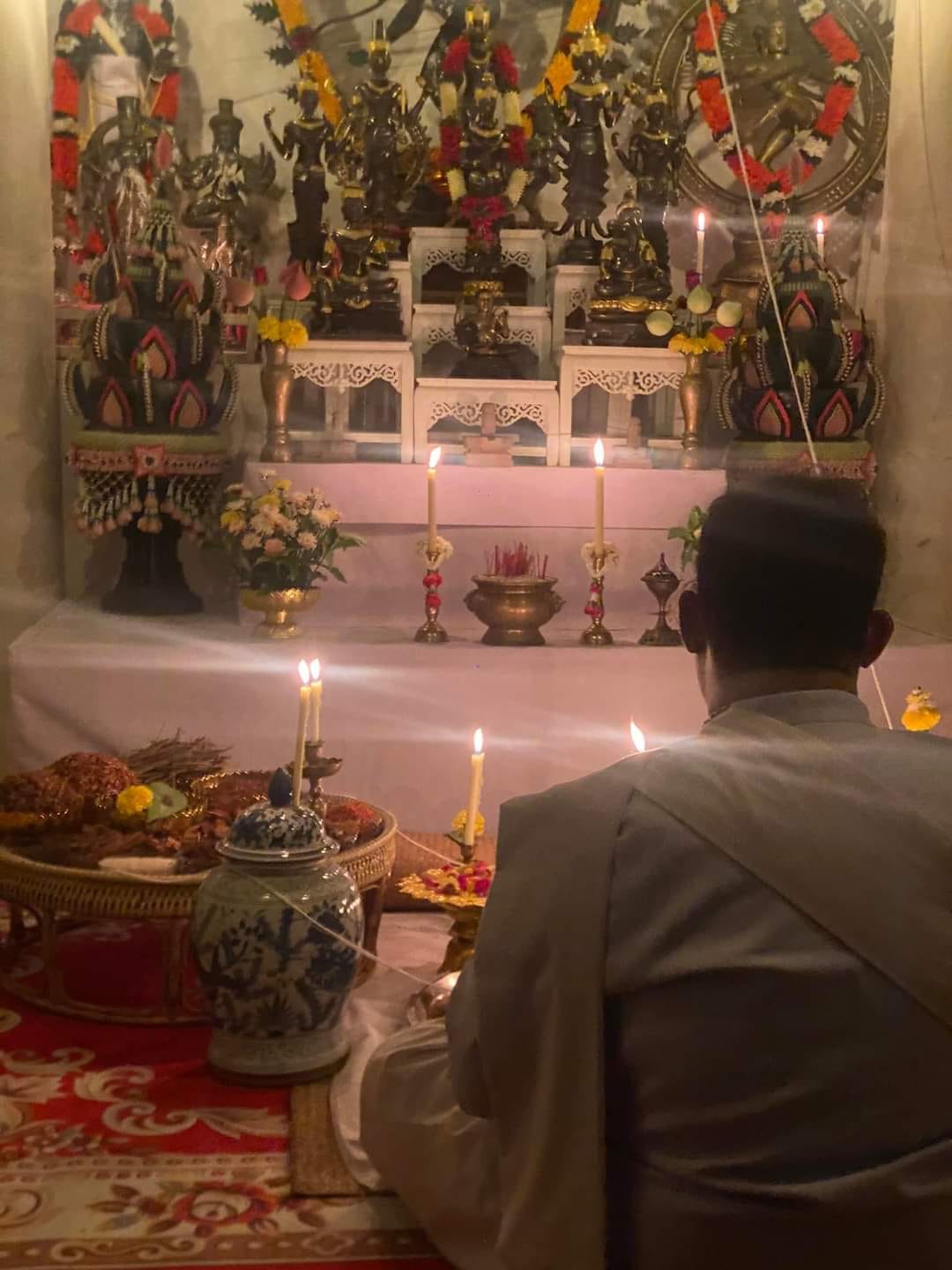 Ceremonial table with candles and offerings for a cleanse negative energy Thai amulet blessing