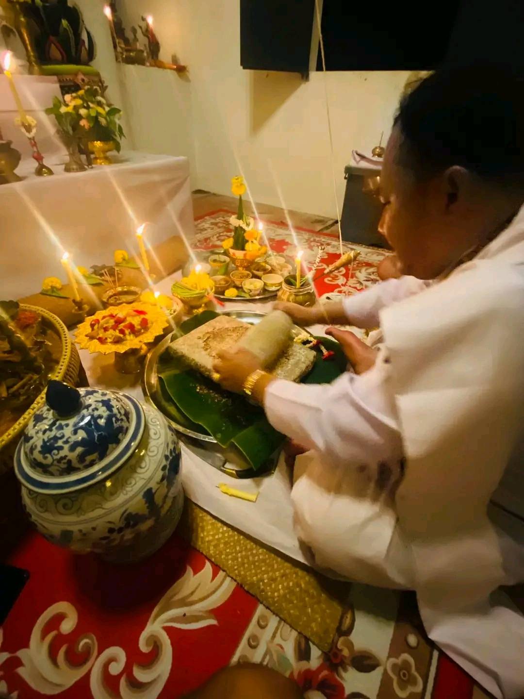 Ceremonial setting with a monk preparing a cleanse negative energy Thai amulet on a decorative altar