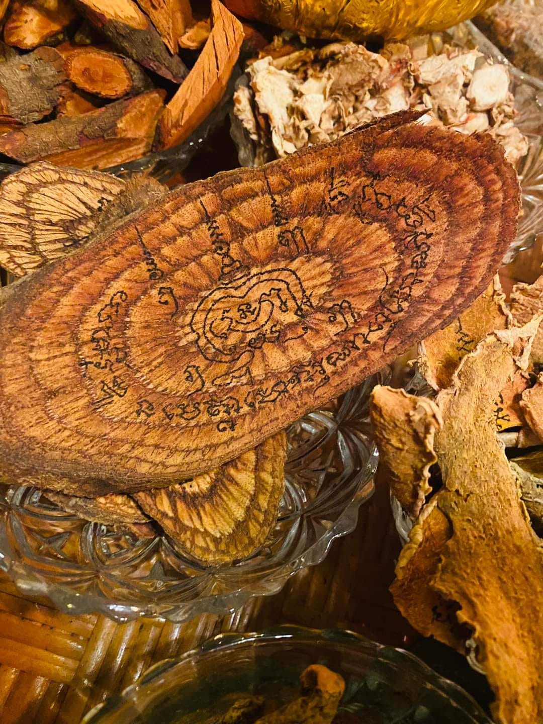Handcrafted Thai amulet made from wood, designed to cleanse negative energy with intricate engravings