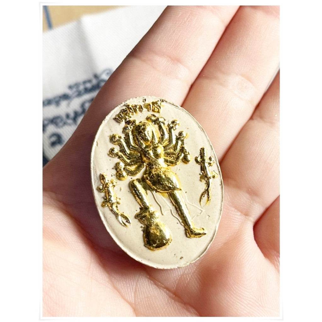 Divine attraction Thai charm with intricate design held in hand for good luck and prosperity