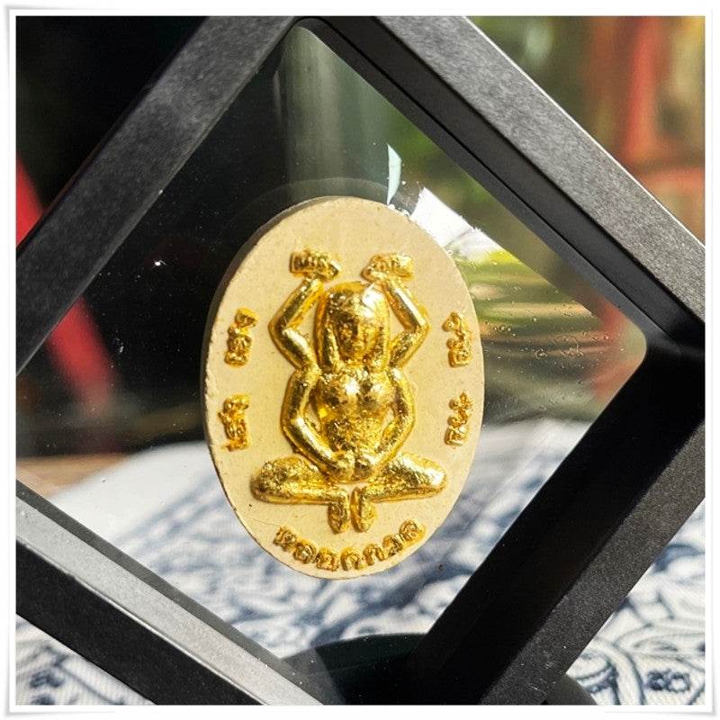 Gold Divine attraction Thai charm displayed in a decorative frame for spiritual and feng shui purposes