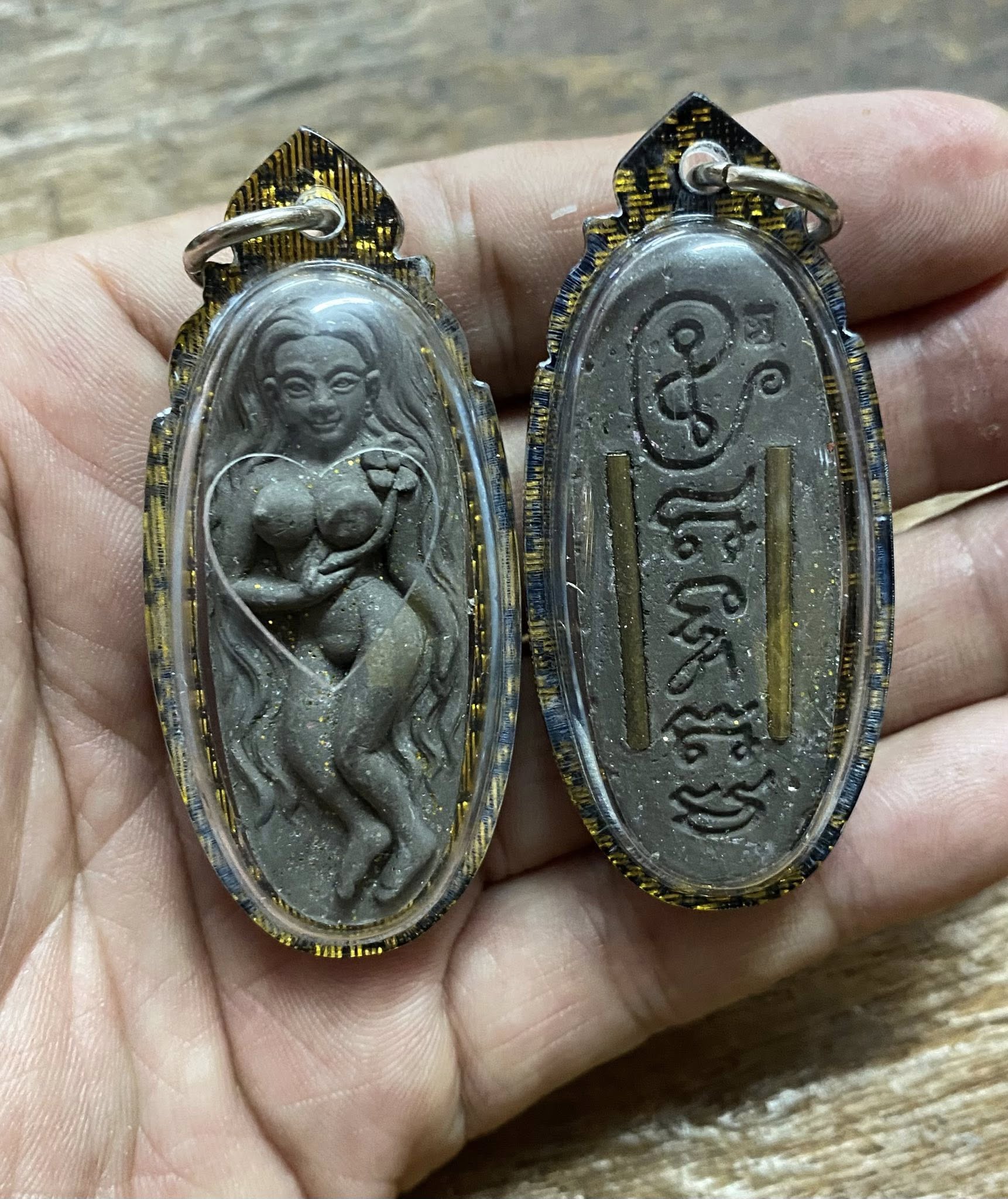 Enchanting Grace Mae Nuea Hom charm with detailed female figure and sacred inscriptions in protective casing