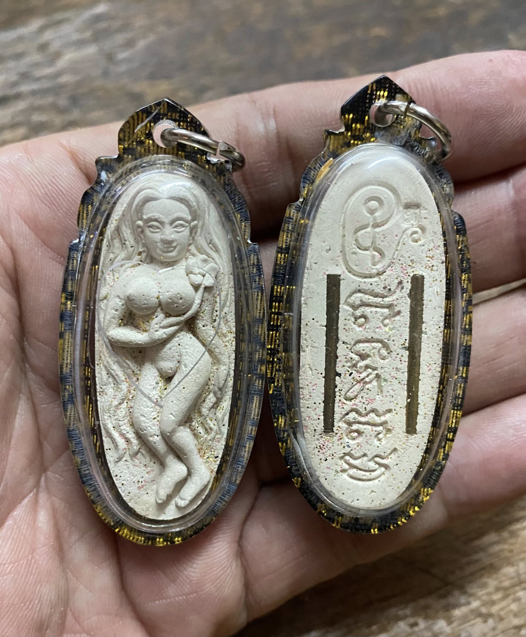 Enchanting Grace Mae Nuea Hom charm amulet with detailed carved figure and sacred inscriptions