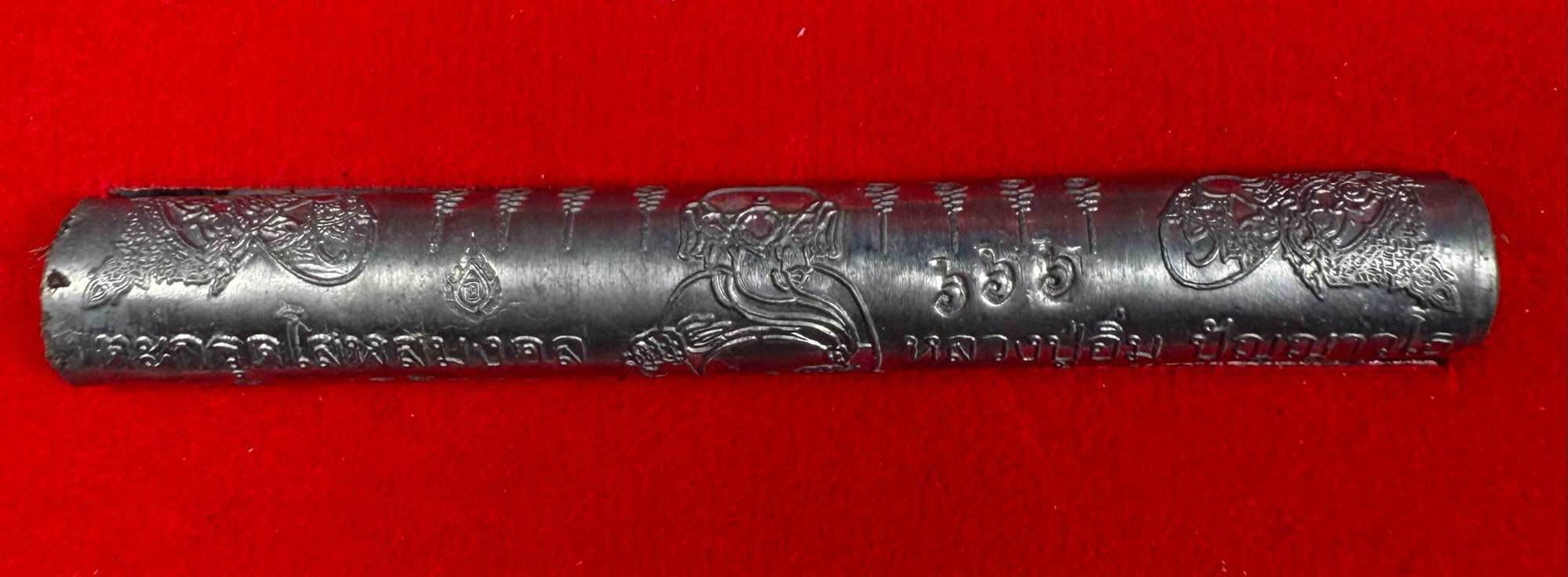 First edition collectible Thai blessing charm engraved metal amulet on red background
