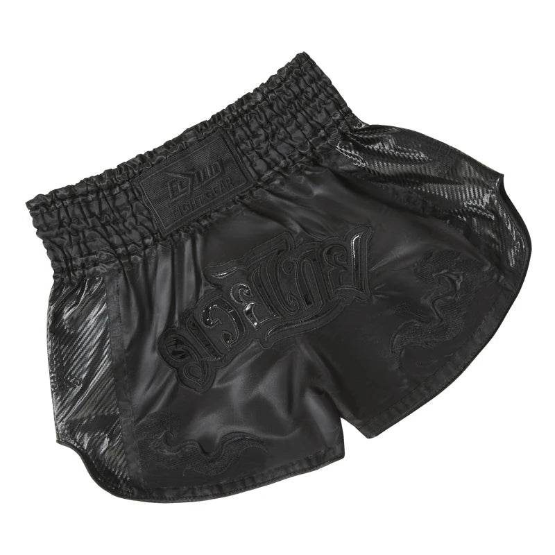Black satin Muay Thai boxing shorts with embossed Thai script and wide elastic waistband for training