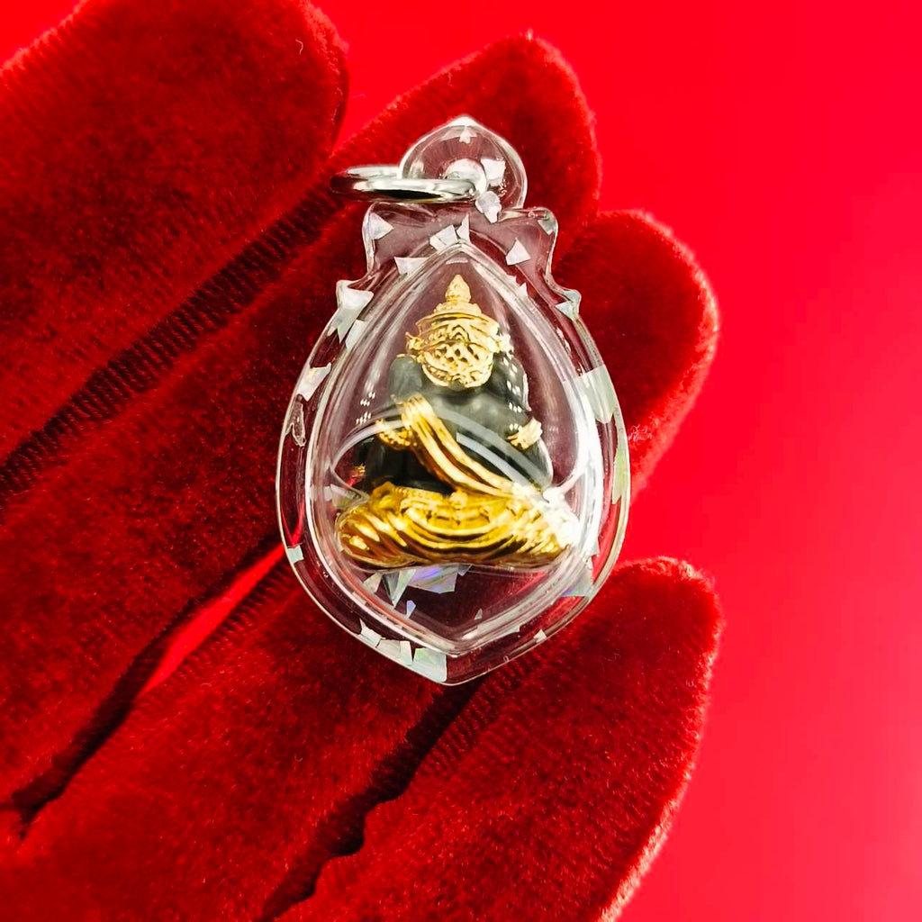 Ganesh amulet for luck and success in a protective clear casing held in a gloved hand