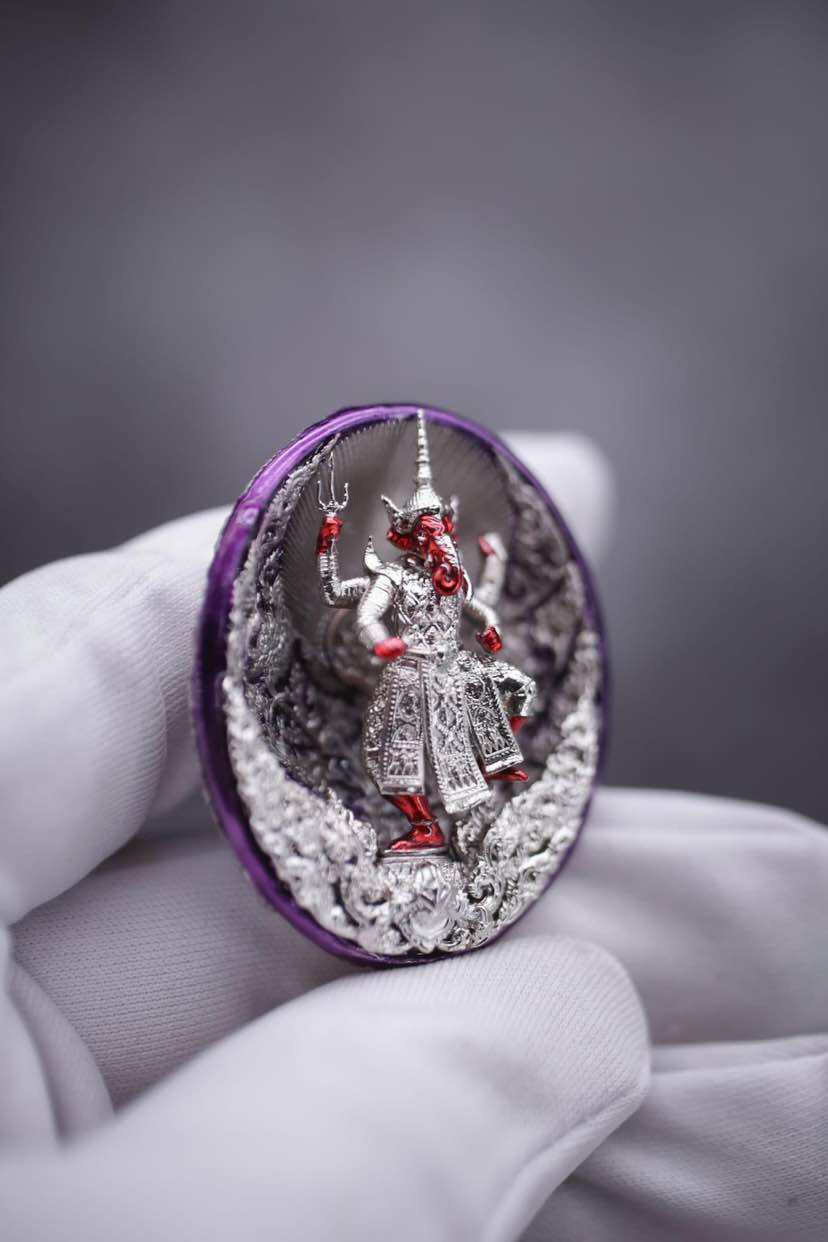 Ganesh coin amulet for wealth displayed in hand, featuring intricate design and vibrant colors