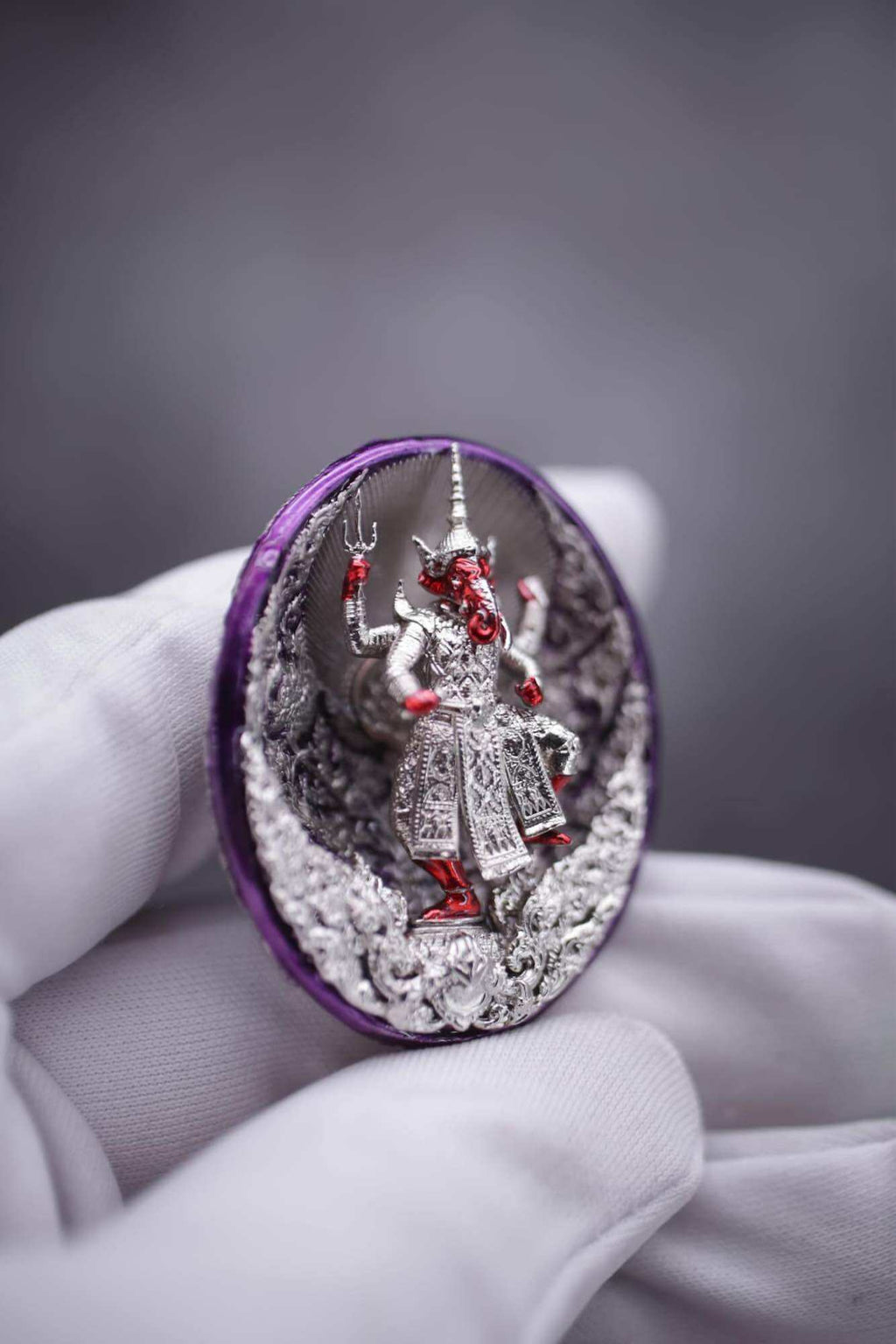 Ganesh coin amulet for wealth showing a detailed figure of Ganesh on a decorative background