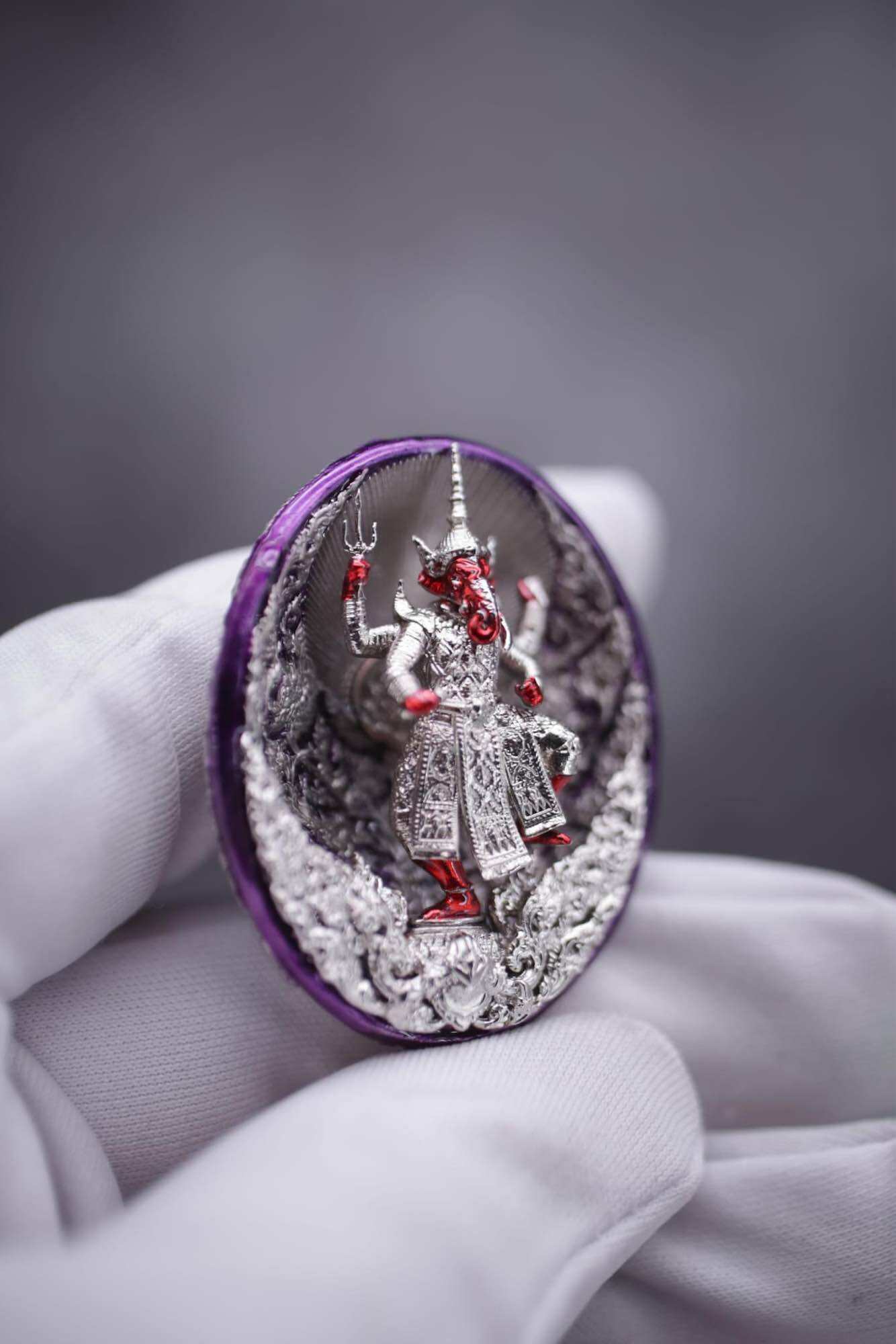 Ganesh coin amulet for wealth showing a detailed figure of Ganesh on a decorative background