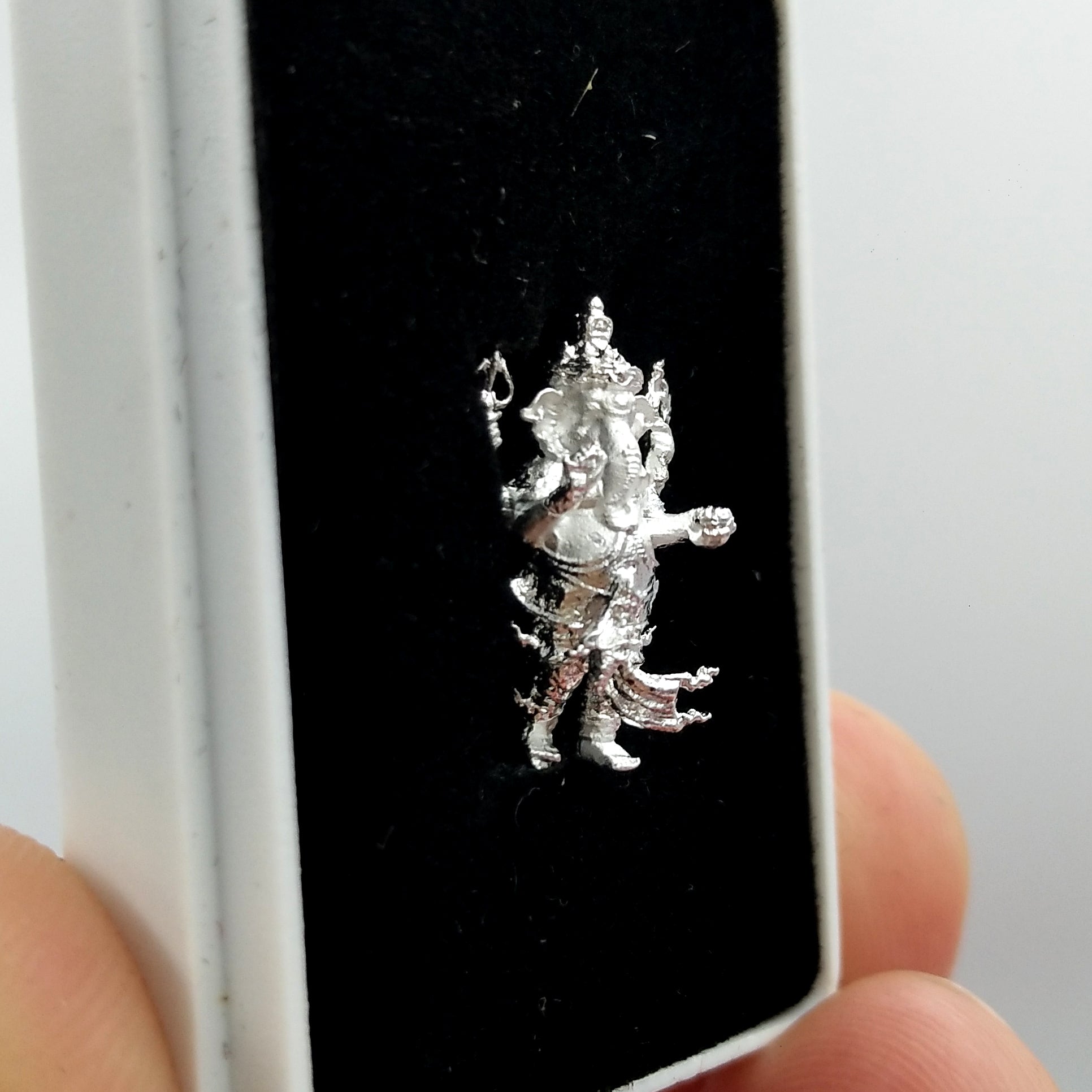 Silver Ganesha amulet for success displayed in a black box, symbolizing prosperity and good fortune
